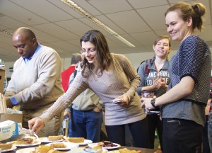 Photo of people selecting pies for early Pi Day celebration.